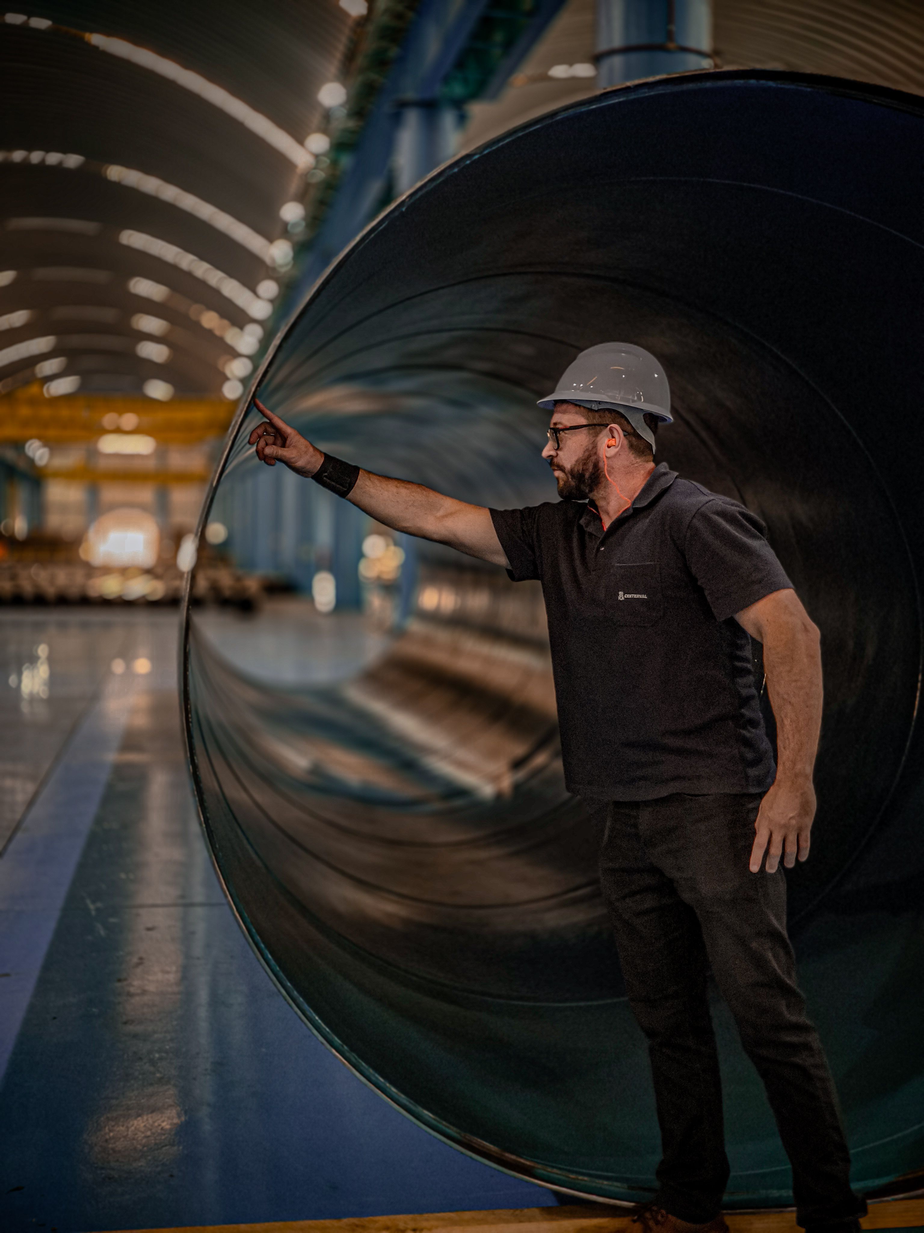 Engineer inspecting a large industrial steel pipe