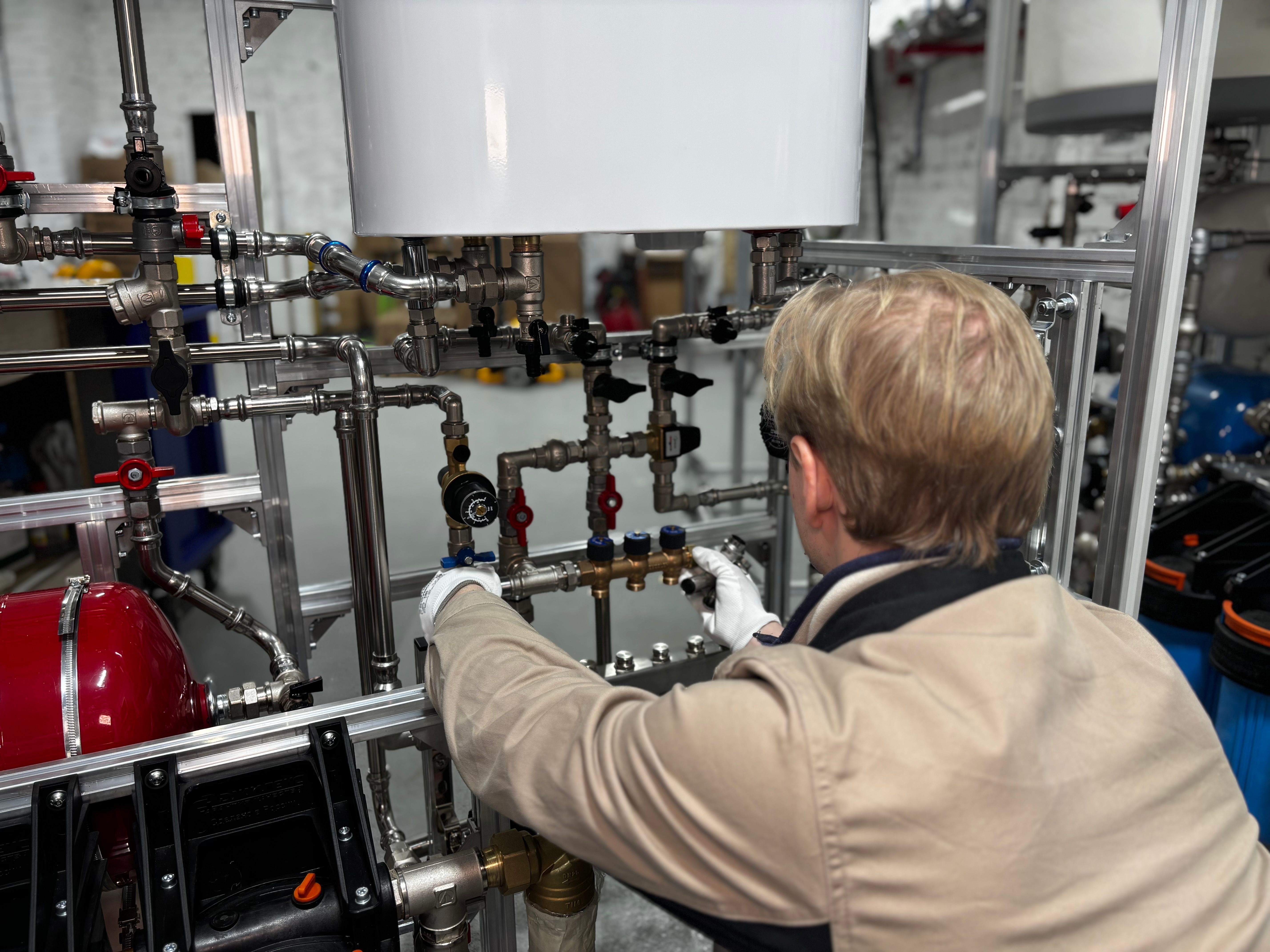 Technician working with an industrial piping system